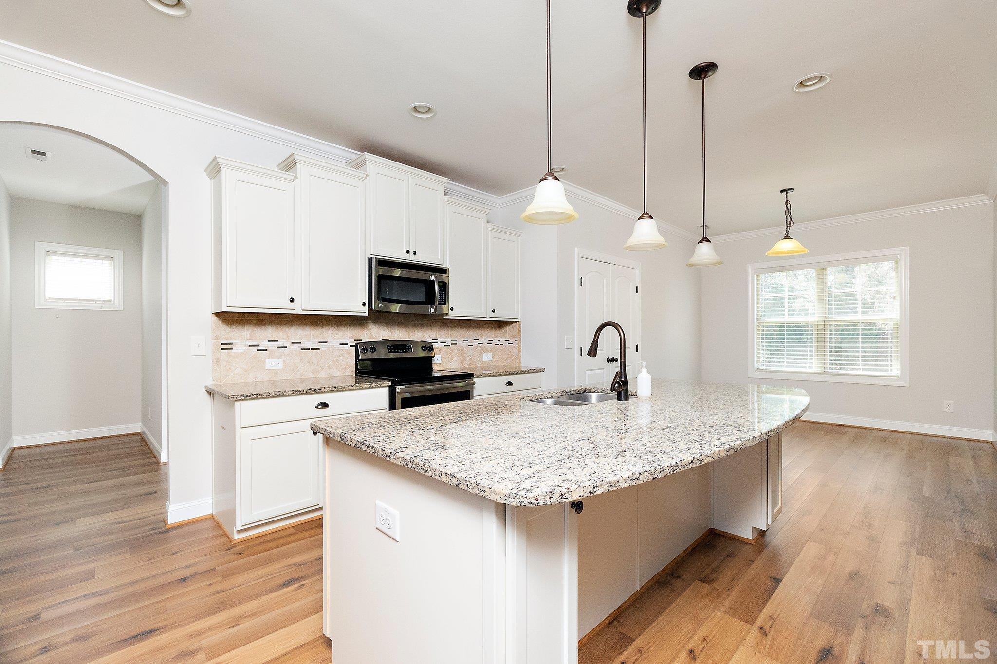 4401 Glengrove Road Raleigh, NC 27616 - Photo 14 of 26 a kitchen with granite countertop a sink a center island stainless steel appliances and cabinets