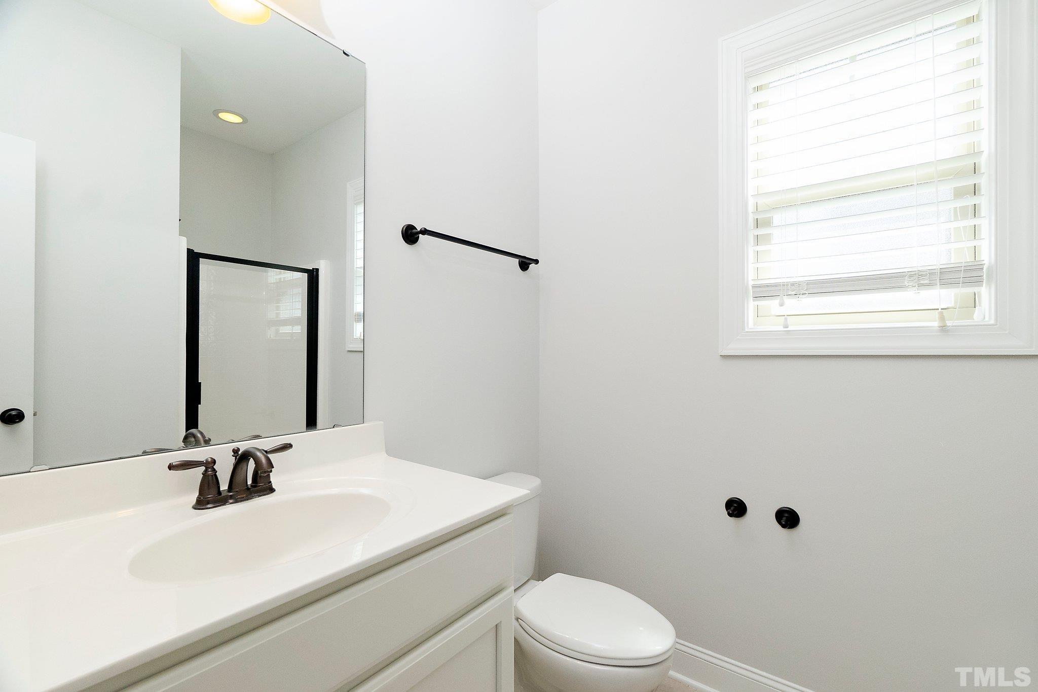 4401 Glengrove Road Raleigh, NC 27616 - Photo 19 of 26 a bathroom with a sink a toilet and a mirror