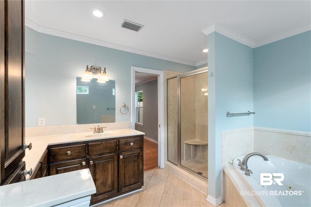 218 Grand Boulevard Mobile, AL 36607 - Photo 5 of 22 Bathroom with shower with separate bathtub, vanity, tile patterned floors, and crown molding