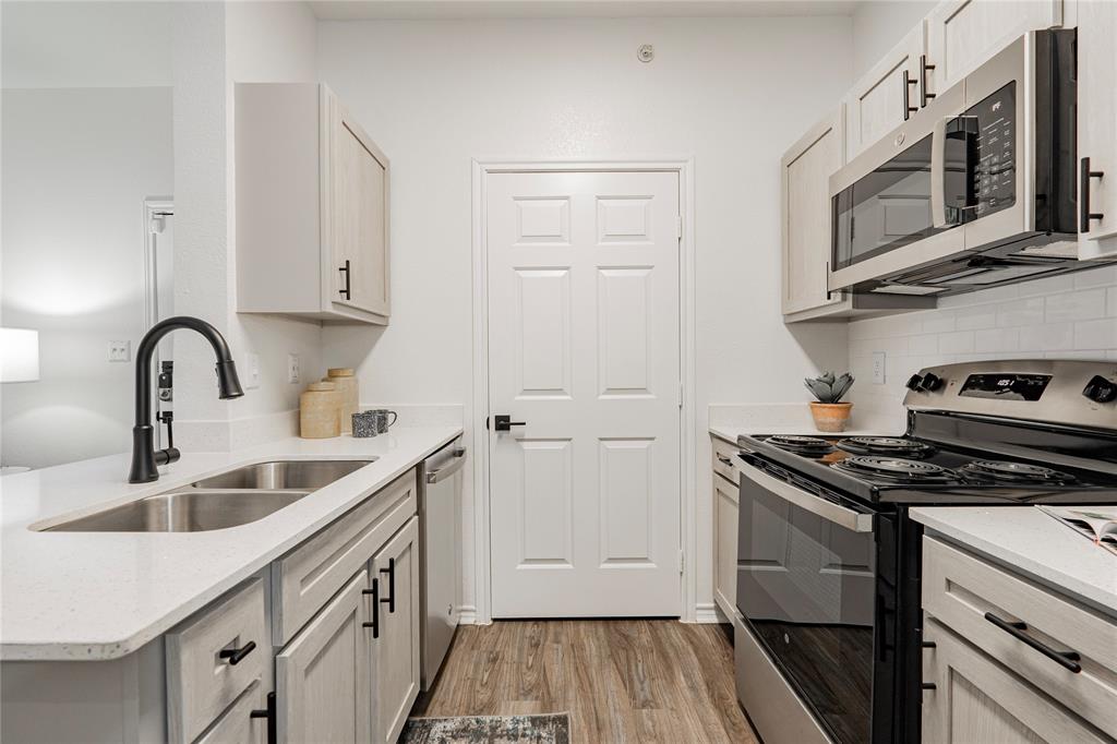 1600 North 9th Street, Unit A1R Midlothian, TX 76065 - Photo 4 of 15 a kitchen with stainless steel appliances granite countertop a sink stove and microwave