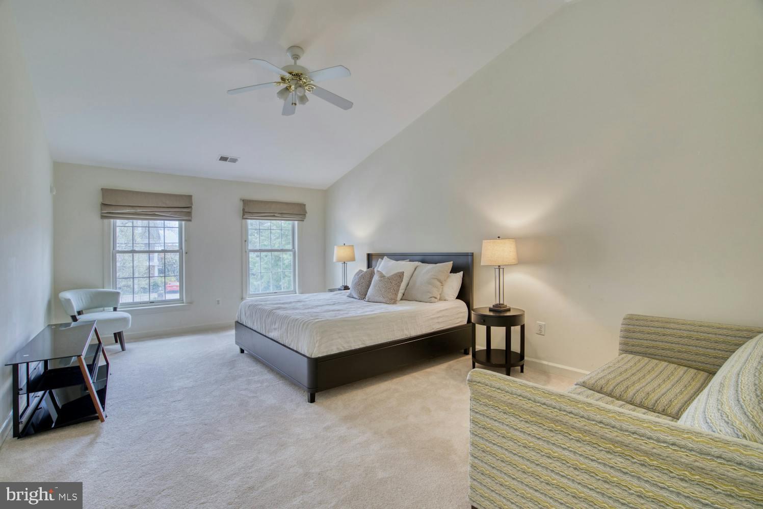 1702 South Arlington Ridge Road Arlington, VA 22202 - Photo 34 of 49 a spacious bedroom with a bed a couch and windows
