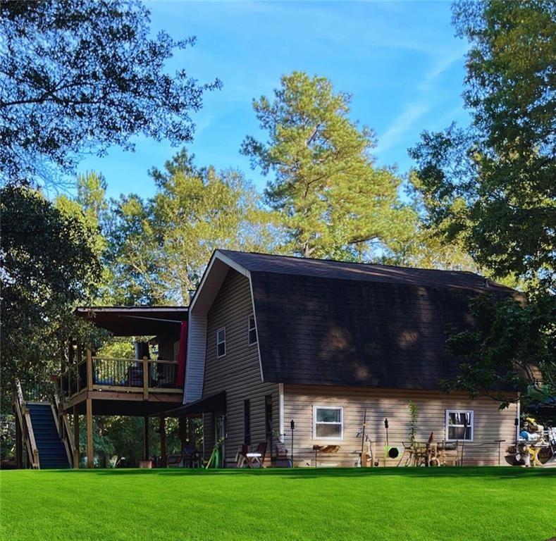 a front view of house with yard and trees in the background
