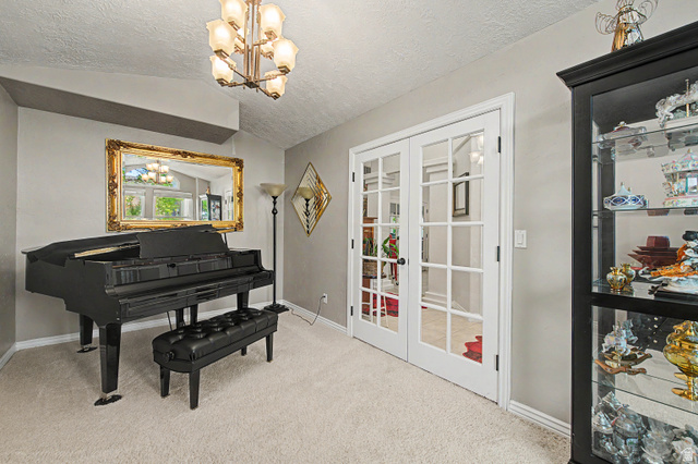 3034 Swiss Drive Santa Clara, UT 84765 - Photo 27 of 59 Spacious interior room featuring vaulted ceilings, plush carpet flooring, and a multi-bulb chandelier