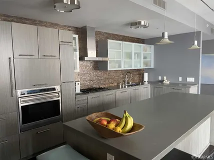 a kitchen with stainless steel appliances granite countertop a sink a stove and a refrigerator
