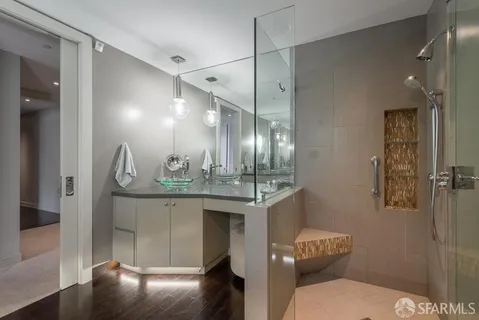 a bathroom with a granite countertop sink a toilet a mirror and shower