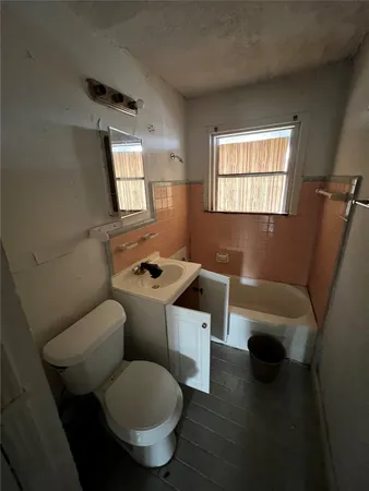 a bathroom with a toilet a sink and a window