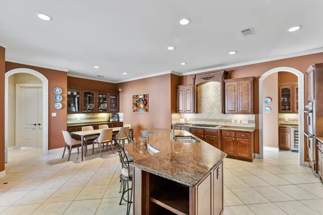 a kitchen with a sink and chairs
