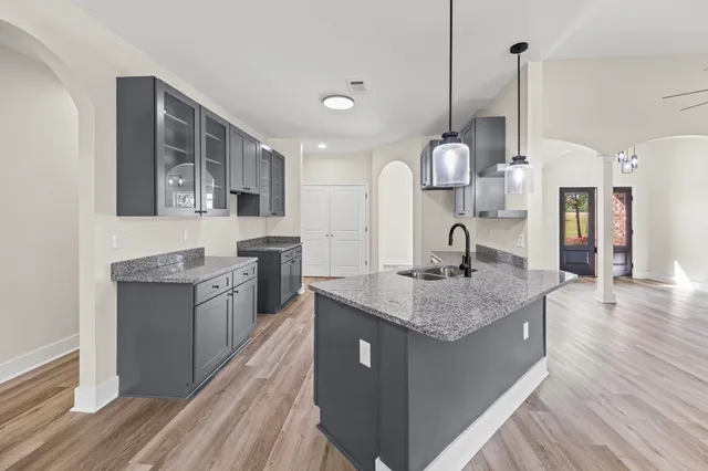 a kitchen with granite countertop cabinets stainless steel appliances and wooden floor