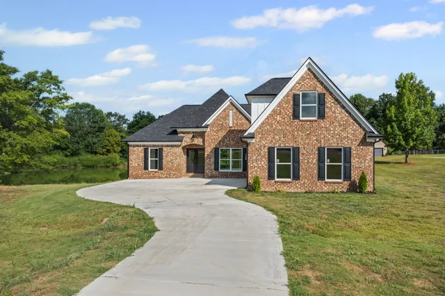 a front view of a house with a yard and trees