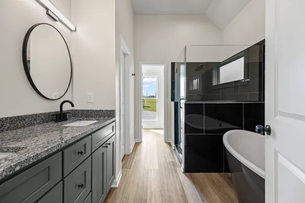 a bathroom with a granite countertop sink a mirror and shower
