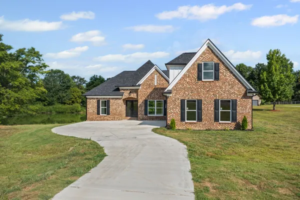 a front view of a house with a yard and trees