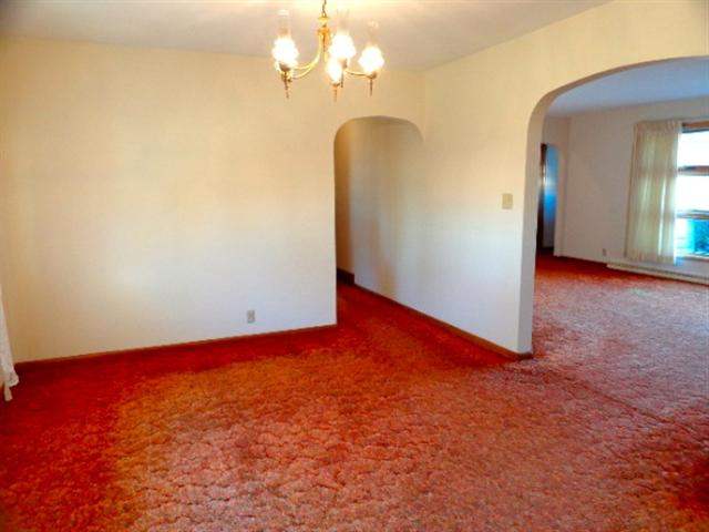 1076 West Becker School Road Freeport, IL 61032 - Photo 4 of 12 an empty room with a chandelier fan and windows