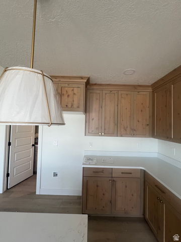 4740 West 25 North West Point, UT 84015 - Photo 7 of 15 Kitchen featuring natural wood-finish cabinetry, light-toned countertops, recessed ceiling lighting, and a decorative pendant light fixture
