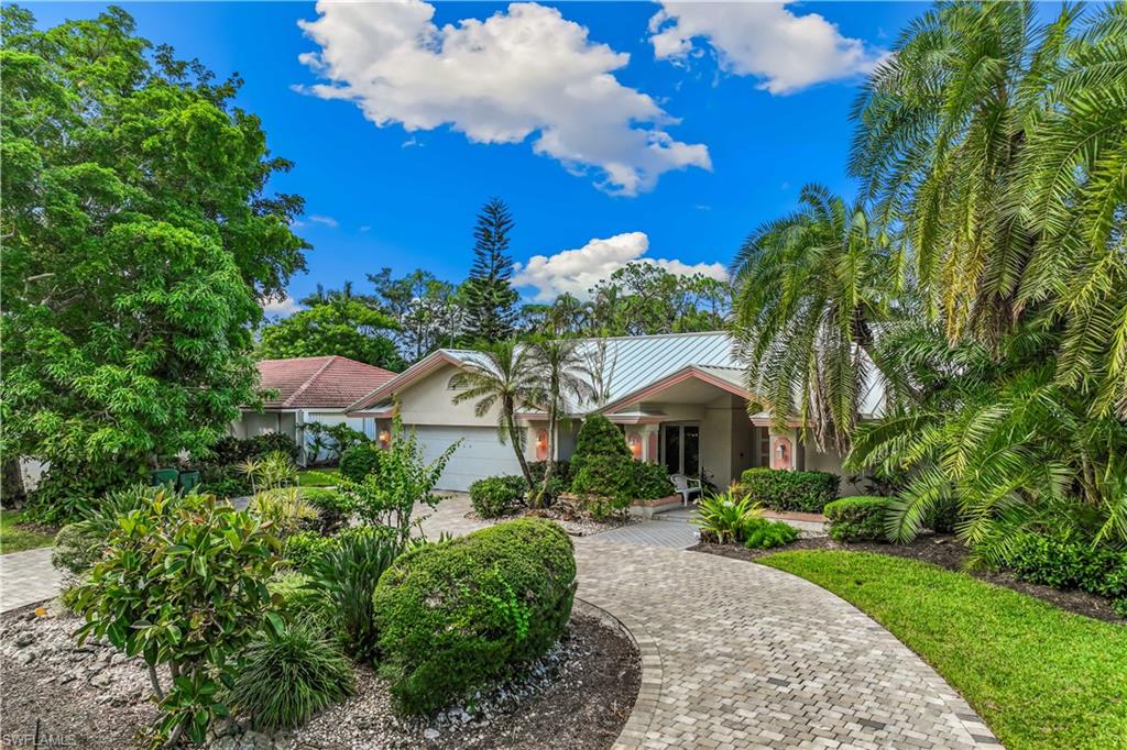 a front view of a house with a yard and fountain