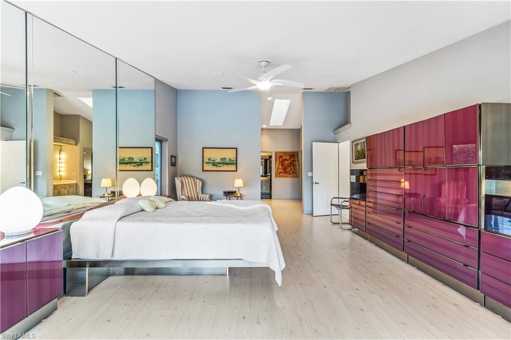 550 Bald Eagle Drive Naples, FL 34105 - Photo 16 of 37 a bedroom with a bed and wooden cabinets