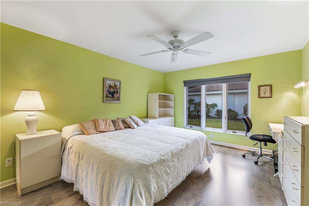 550 Bald Eagle Drive Naples, FL 34105 - Photo 20 of 37 a bedroom with a bed table chair and a window