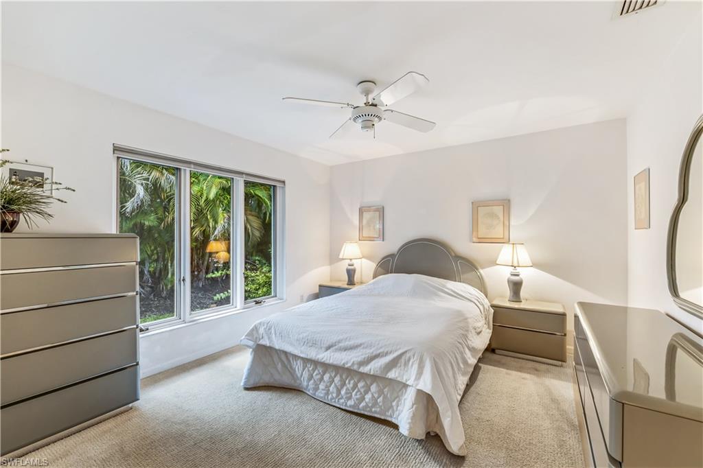 550 Bald Eagle Drive Naples, FL 34105 - Photo 21 of 37 a bedroom with a bed and a table