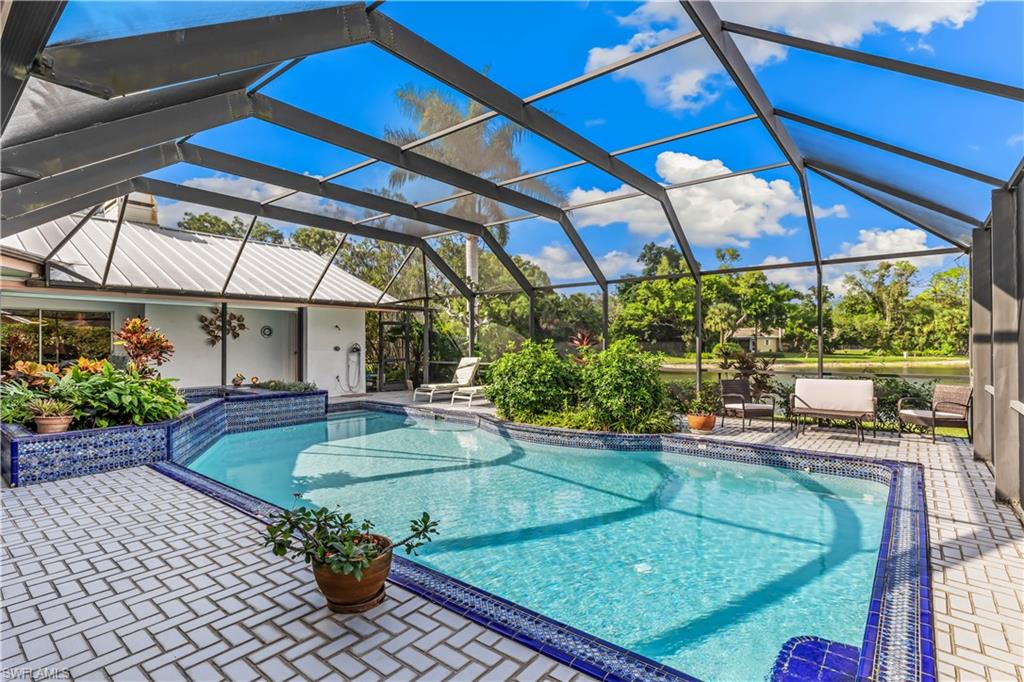 550 Bald Eagle Drive Naples, FL 34105 - Photo 32 of 37 a view of a backyard with table and chairs under an umbrella