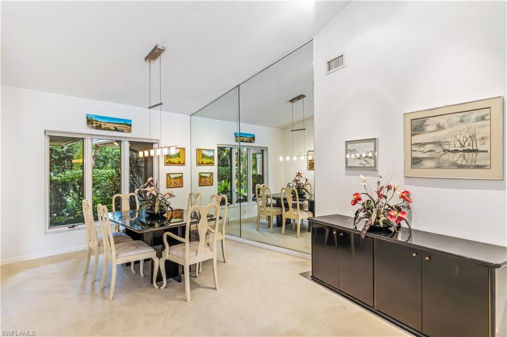 550 Bald Eagle Drive Naples, FL 34105 - Photo 6 of 37 a view of a dining room and livingroom with furniture wooden floor a chandelier
