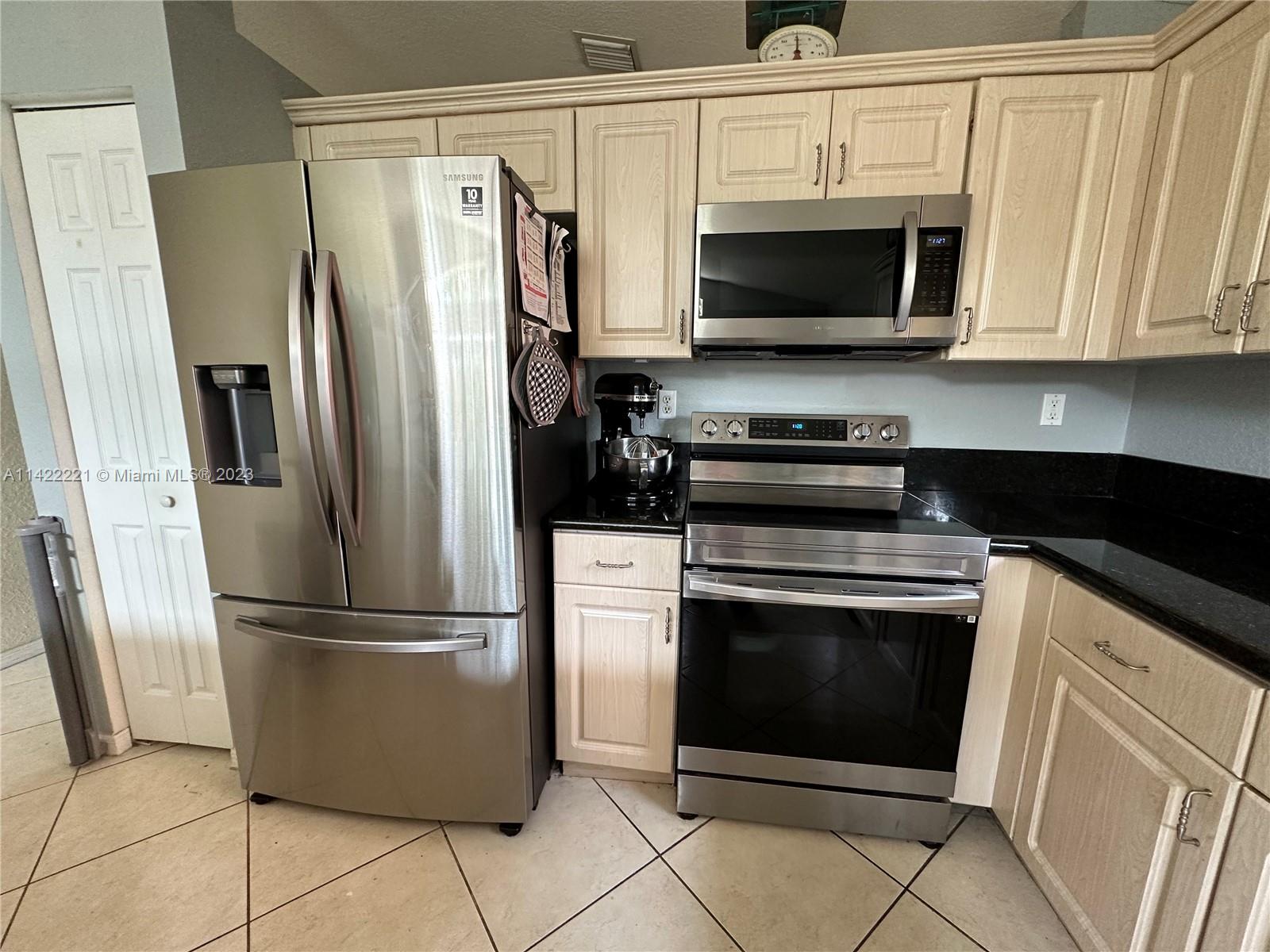 1041 Southeast 20th Road Homestead, FL 33035 - Photo 14 of 40 a kitchen with stainless steel appliances granite countertop a refrigerator stove and microwave