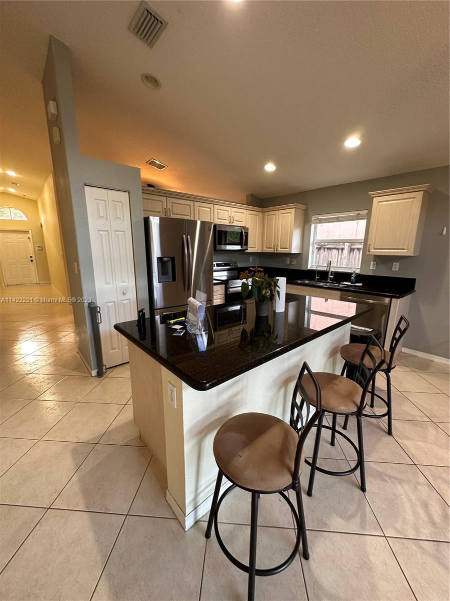 1041 Southeast 20th Road Homestead, FL 33035 - Photo 20 of 40 a kitchen with stainless steel appliances kitchen island granite countertop a sink and cabinets