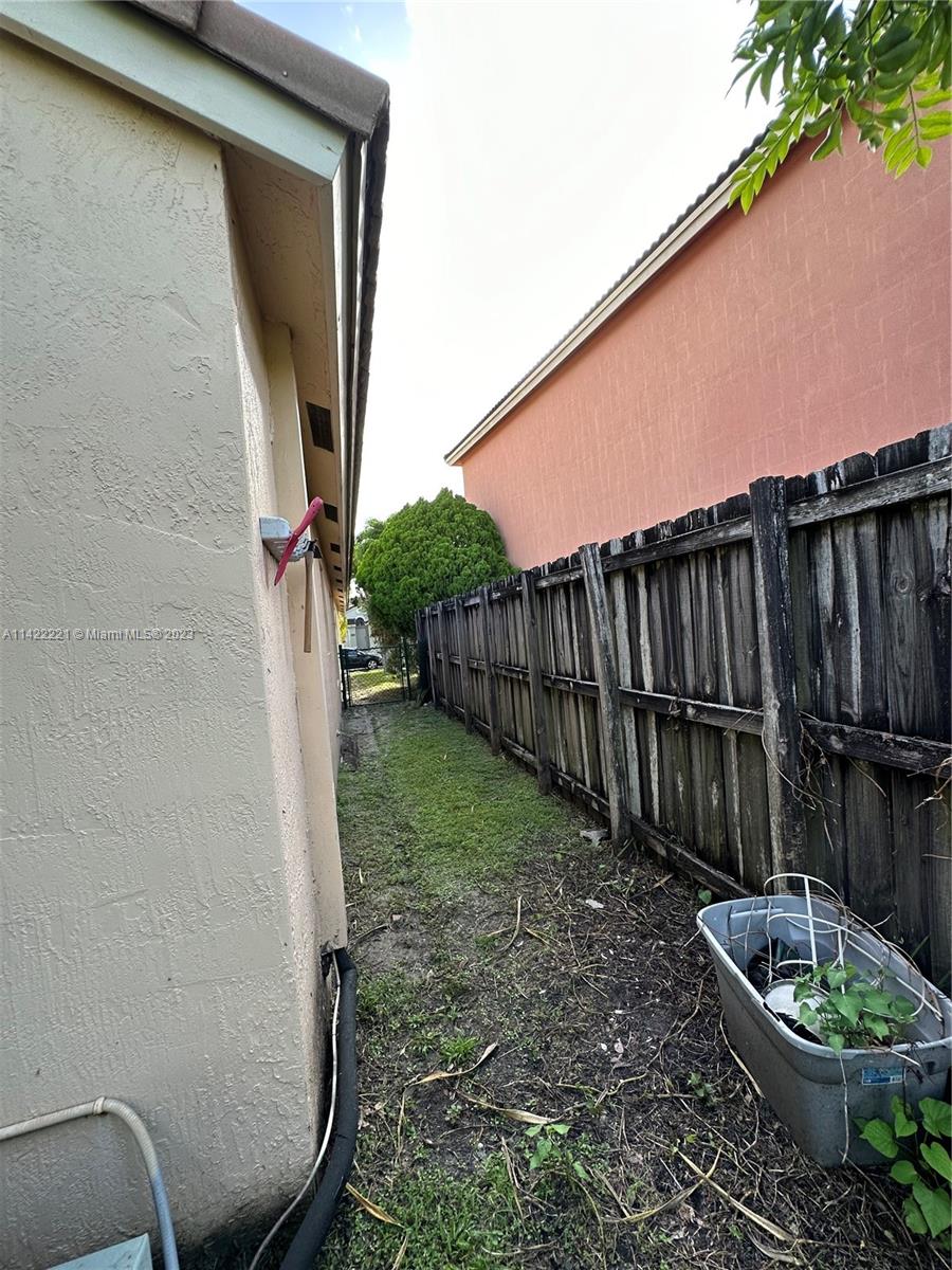 1041 Southeast 20th Road Homestead, FL 33035 - Photo 33 of 40 a backyard of a house with wooden fence and a bench