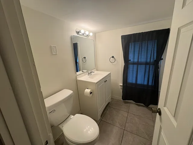 a bathroom with a sink a toilet a mirror and vanity