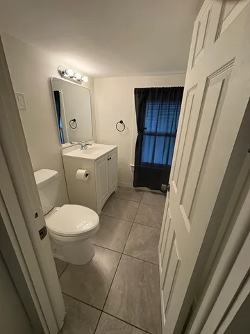 a bathroom with a toilet a sink a mirror and vanity