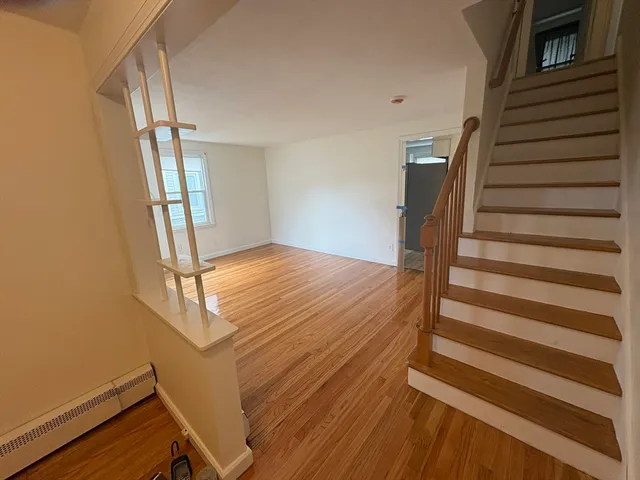 a view of a livingroom with wooden floor and stairs