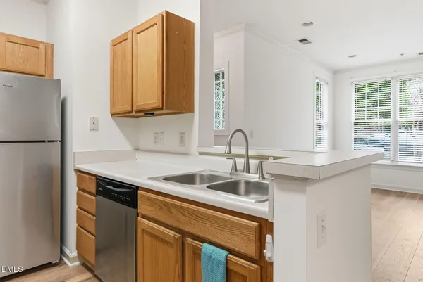 a kitchen with stainless steel appliances granite countertop a sink and a refrigerator