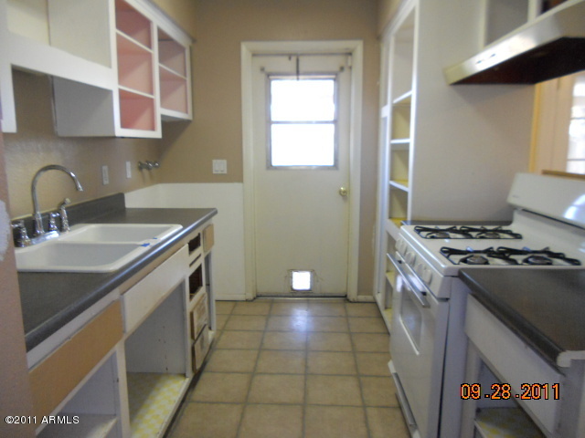 2901 West Bloomfield Road Phoenix, AZ 85029 - Photo 2 of 9 a kitchen with a sink stove top oven and cabinets