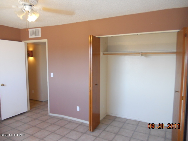 2901 West Bloomfield Road Phoenix, AZ 85029 - Photo 8 of 9 a view of an empty room with wooden floor and a ceiling fan
