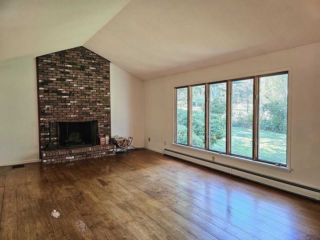 47 Stagecoach Road Amherst, MA 01002 - Photo 4 of 38 wooden floor in an empty room with a fireplace