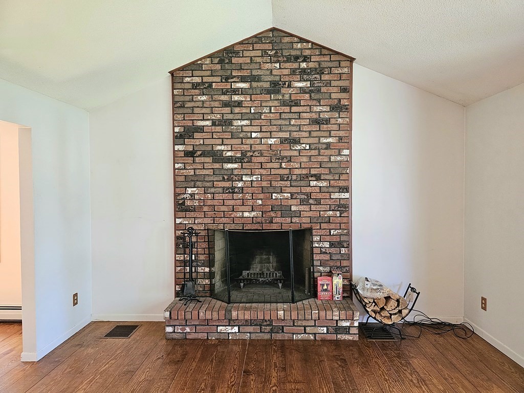 47 Stagecoach Road Amherst, MA 01002 - Photo 6 of 38 a living room with a fireplace and wooden floor