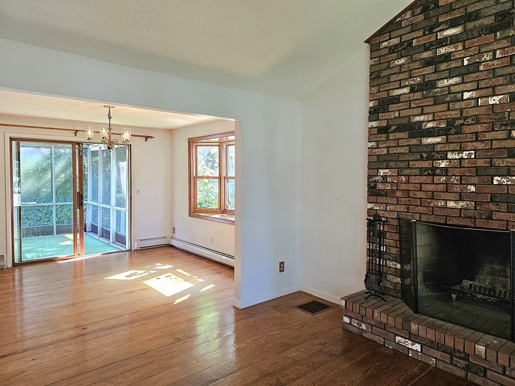 47 Stagecoach Road Amherst, MA 01002 - Photo 7 of 38 a view of an empty room with wooden floor fireplace and a window