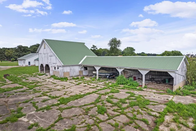 a view of an empty room with window chandelier fan and kitchen view