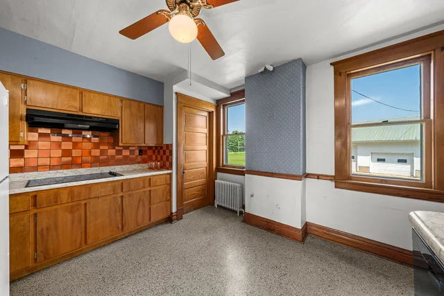 a view of an empty room with window wooden floor and a fireplace