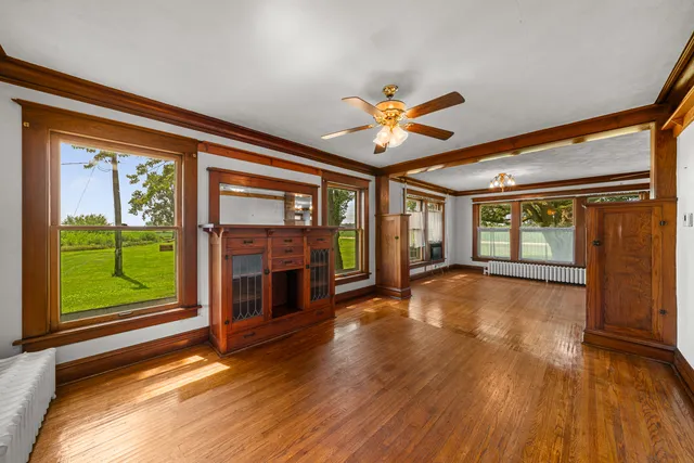 a view of empty room with wooden floor and fan