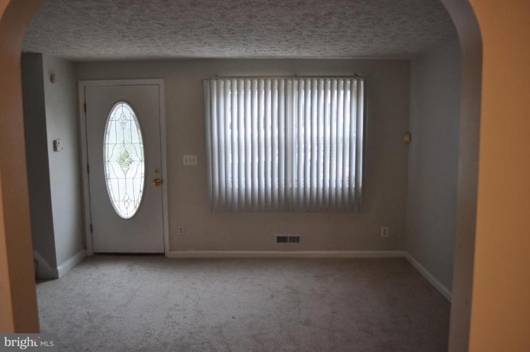 5506 Channing Road Baltimore, MD 21229 - Photo 3 of 15 an empty room with window mirror and windows