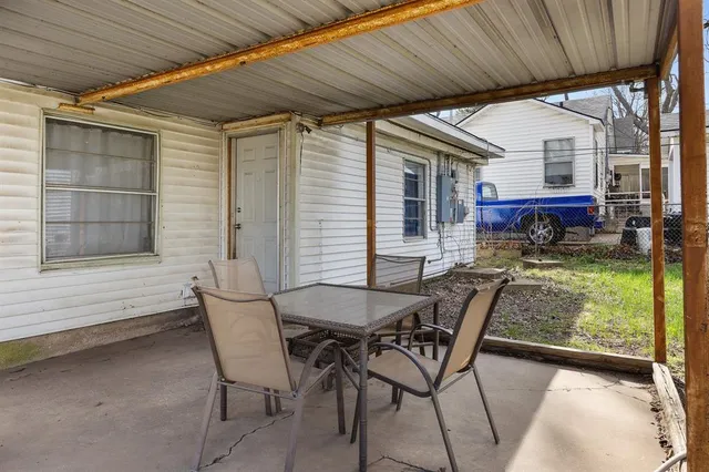 a view of a patio with table and chairs with wooden floor and fence
