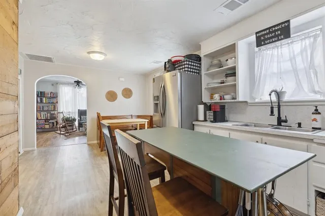 a kitchen with a table chairs sink and cabinets