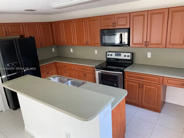 a kitchen with stainless steel appliances a stove a microwave a sink and a refrigerator