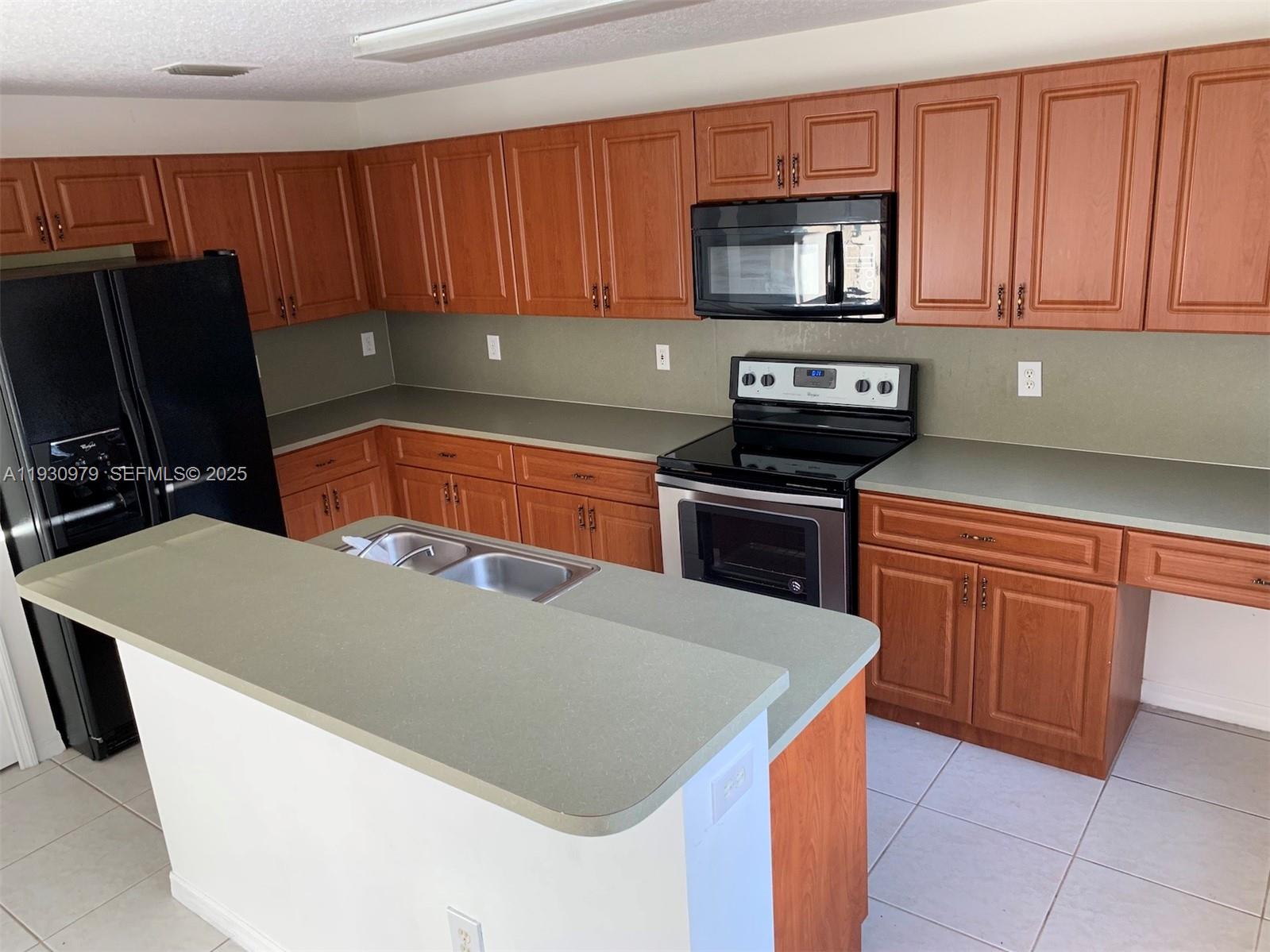3150 Southwest 152nd Place, Unit 3150 Miami, FL 33185 - Photo 4 of 25 a kitchen with stainless steel appliances a stove a microwave a sink and a refrigerator