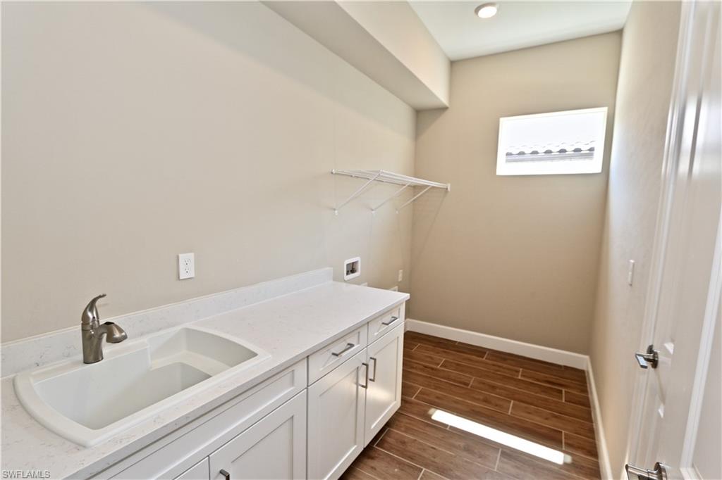 8437 Rosa Court Naples, FL 34114 - Photo 16 of 32 a bathroom with a sink and a white cabinet