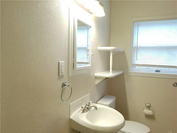 a bathroom with a toilet sink vanity and mirror