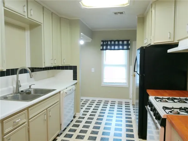 a kitchen with a sink a refrigerator and cabinets