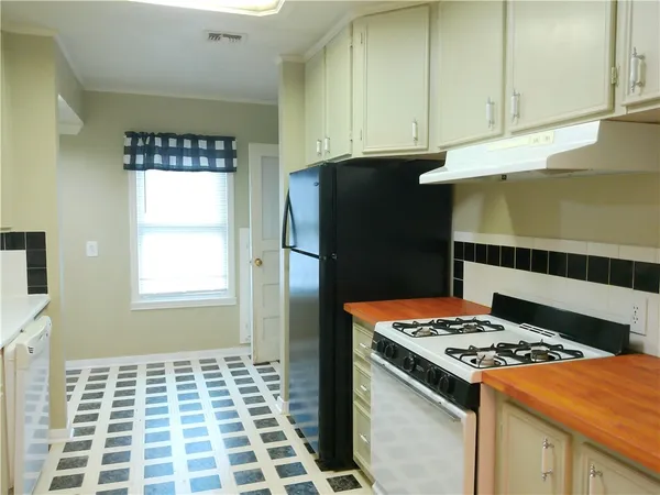 a kitchen with a stove a refrigerator and cabinets