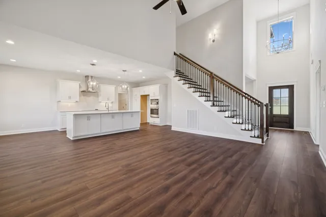 a kitchen with stainless steel appliances granite countertop a dishwasher a stove and a wooden floor