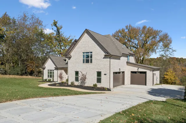 a view of a yard in front of a house with large tree