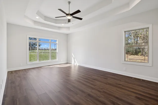 an empty room with ceiling fan and window